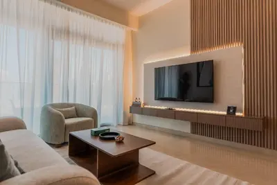 a living room with a tv and a couch and a table at TRPS - Imperial Avenue, Downtown - Burj Khalifa View, Brand New, Amazing Facilities in Dubai