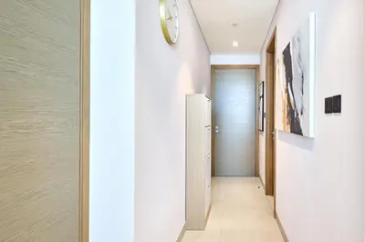 a hallway with a door and a clock on the wall at STAY BY LATINEM Luxury 1BR Holiday Home W 2809 Near Burj Khalifa in Dubai
