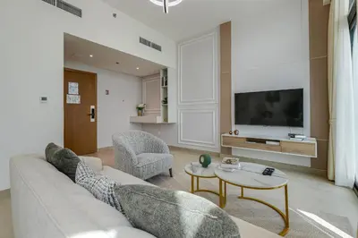 a living room with a couch and a tv at Fawad Azizi Residence, Al Jaddaf- 1BR - Allsopp & Allsopp in Dubai