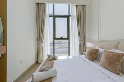a bedroom with a large bed with a large window at Fawad Azizi Residence, Al Jaddaf- 1BR - Allsopp & Allsopp in Dubai