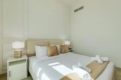 a bedroom with a large white bed with towels on it at Fawad Azizi Residence, Al Jaddaf- 1BR - Allsopp & Allsopp in Dubai