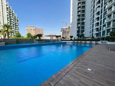 a large swimming pool in a city with tall buildings at Fawad Azizi Residence, Al Jaddaf- 1BR - Allsopp & Allsopp in Dubai