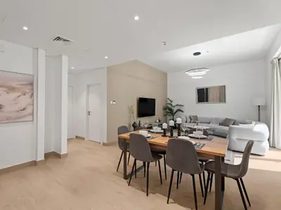 a dining room and living room with a table and chairs at Coastal Haven 1BDR in La Cote B4-12 in Dubai
