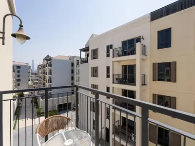 a balcony with a table and chairs and buildings at Coastal Haven 1BDR in La Cote B4-12 in Dubai