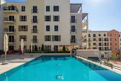 a swimming pool in front of a building at Coastal Haven 1BDR in La Cote B4-12 in Dubai