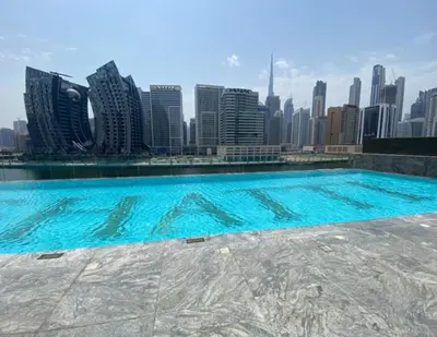 a swimming pool with a city skyline in the background at Bright Studio in Binghatti Canal in Dubai
