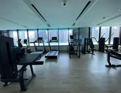 a gym with treadmills and cardio equipment in a building at Bright Studio in Binghatti Canal in Dubai