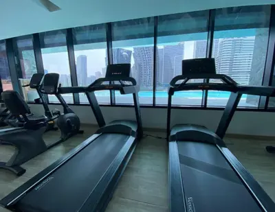 a gym with three treadmills in front of a window at Bright Studio in Binghatti Canal in Dubai