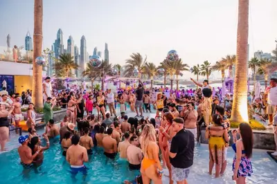 a crowd of people in the water at a swimming pool at FIVE Palm Jumeirah 3BR plus Luxury Lifestyle Residence in Dubai