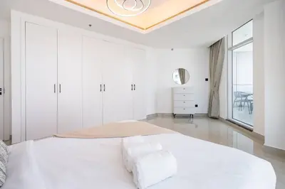 a white bedroom with a large bed and a window at High-Floor Upgraded 3-Bed Marina Apartment in Dubai