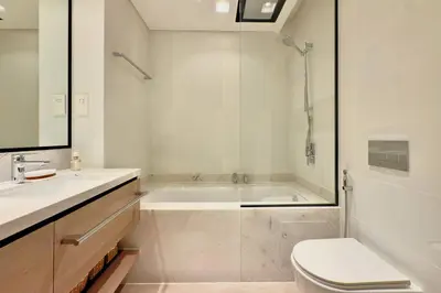 a bathroom with a tub and a toilet and a sink at Luxury 1 Bed Apt in Palace, Dubai Creek Harbour in Dubai
