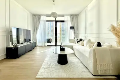 a living room with a white couch and a tv at Luxury 1 Bed Apt in Palace, Dubai Creek Harbour in Dubai