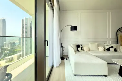 a living room with a white couch and a large window at Luxury 1 Bed Apt in Palace, Dubai Creek Harbour in Dubai