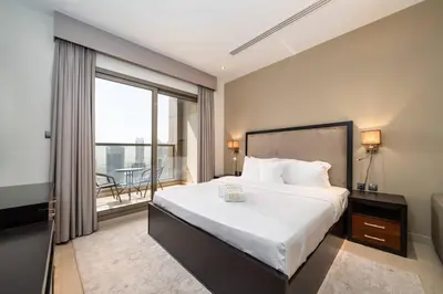 a bedroom with a large bed and a balcony at Stylish and Spacious Downtown Studio in Dubai
