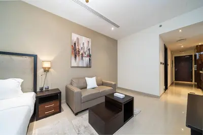 a bedroom with a bed and a couch and a table at Stylish and Spacious Downtown Studio in Dubai