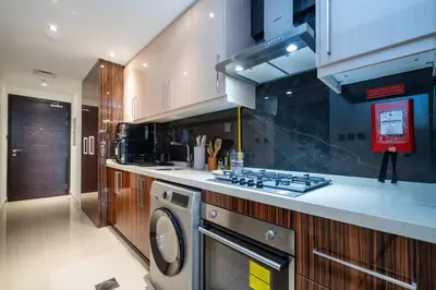 a kitchen with a stove and a washing machine at Stylish and Spacious Downtown Studio in Dubai
