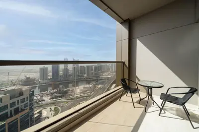 a balcony with two chairs and a table on a building at Stylish and Spacious Downtown Studio in Dubai