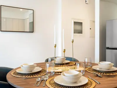 a dining room table with plates and glasses on it at Iconic Burj and Fountain View 2BR Downtown in Dubai