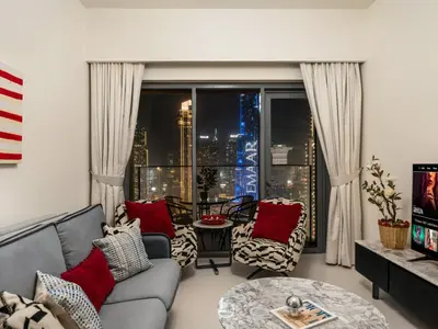 a living room with a couch and a large window at Iconic Burj and Fountain View 2BR Downtown in Dubai
