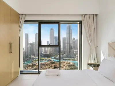 a bedroom with a large window with a city view at Iconic Burj and Fountain View 2BR Downtown in Dubai