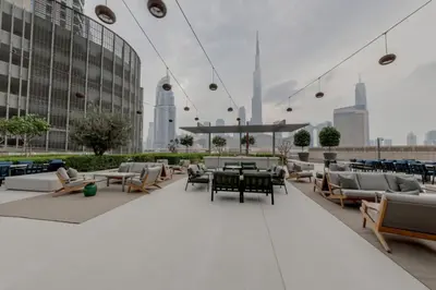 a rooftop patio with chairs and tables and buildings at New 2BR Luxe Vida Dubai Mall Direct Access in Dubai