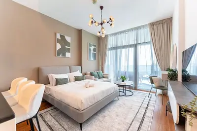 a bedroom with a bed and a living room at HAVN - Studio in Al Jawhara, JVT in Dubai
