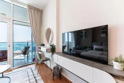 a living room with a large tv on a wall at HAVN - Studio in Al Jawhara, JVT in Dubai