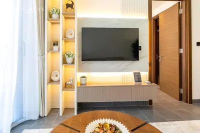 a living room with a television and a table at Luxury 1BR Burj Khalifa & Flamingo Sanctuary Views in Dubai