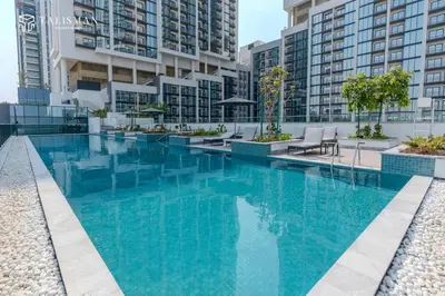 a large swimming pool with blue water in a building at Luxury 1BR Burj Khalifa & Flamingo Sanctuary Views in Dubai
