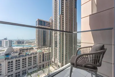 a chair on a balcony with a view of a city at Luxury Leisure Massive Pool Oasis in Amna Tower in Dubai
