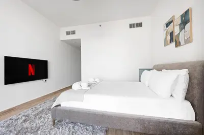 a bedroom with a bed and a tv on a wall at Luxury Leisure Massive Pool Oasis in Amna Tower in Dubai