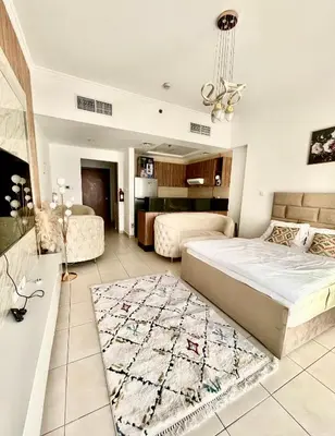 a bedroom with a bed and a living room at Spacious Modern High Floor Independent Studio Downtown in Dubai