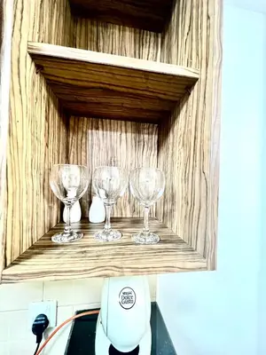 a shelf with three wine glasses on it at Spacious Modern High Floor Independent Studio Downtown in Dubai