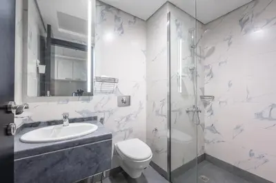 a bathroom with a toilet and a sink and a shower at Brand New Designer Space with All Modern Amenities in Dubai