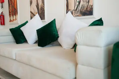 a white couch with green and white pillows on it at Luxury 1 Bedroom with Pool Dubai Frame Museum View in Dubai