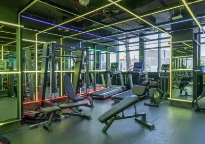 a gym with rows of treadmills and exercise bikes at City Forest Studio in JVC in Dubai