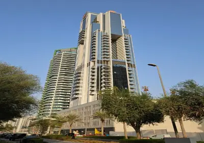 a tall white building with trees in front of it at City Forest Studio in JVC in Dubai