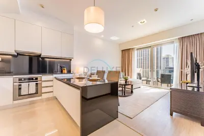 a kitchen with white cabinets and a large window at Panoramic Dubai Water Canal Views 1BR with Seamless Access to Marina Mall, Steps from the Tram, The Address Residences, Dubai Marina by Deluxe Holiday Homes in Dubai