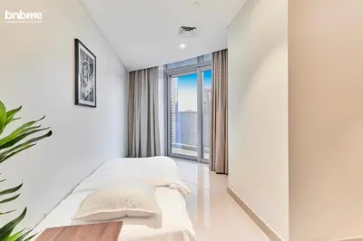 a bedroom with two beds and a large window at bnbmehomes - Imperial Avenue in Dubai