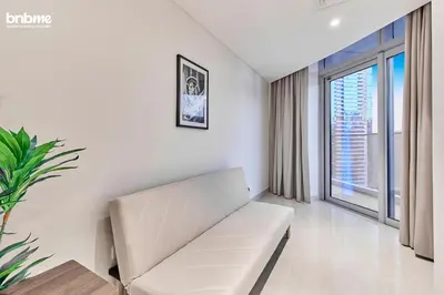 a living room with a white couch and a large window at bnbmehomes - Imperial Avenue in Dubai