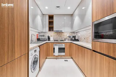 a kitchen with a washer and dryer and a tv at bnbmehomes - Imperial Avenue in Dubai