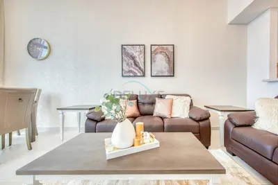 a living room with a couch and a table at Fresh 2BR at Mudon Views 4, Dubailand by Deluxe Holiday Homes in Dubai
