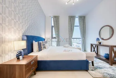 a bedroom with a bed and a table and a mirror at Fresh 2BR at Mudon Views 4, Dubailand by Deluxe Holiday Homes in Dubai