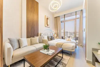 a living room with a couch and a table at Studio Near Meydan Racecourse and Golf Club with Convenient Access to Al Meydan Road and Dubai Top Attractions, Azizi Riviera 29, Al Merkadh by Deluxe Holiday Homes in Dubai