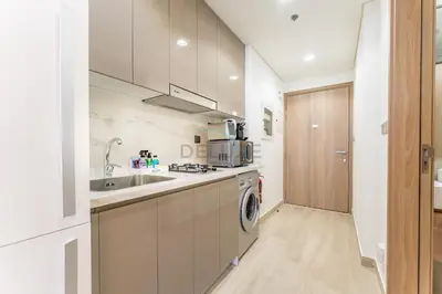 a kitchen with a sink and a washing machine at Studio Near Meydan Racecourse and Golf Club with Convenient Access to Al Meydan Road and Dubai Top Attractions, Azizi Riviera 29, Al Merkadh by Deluxe Holiday Homes in Dubai