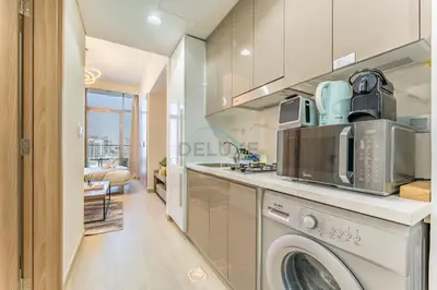 a kitchen with a washer and dryer at Studio Near Meydan Racecourse and Golf Club with Convenient Access to Al Meydan Road and Dubai Top Attractions, Azizi Riviera 29, Al Merkadh by Deluxe Holiday Homes in Dubai