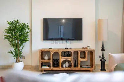 a living room with a tv on a wall at Located Near Museum of the Future and Index Mall, Just a few Minutes Drive from Burj Khalifa and Dubai Mall - Sky Gardens, DIFC by Deluxe Holiday Homes in Dubai