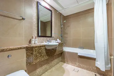 a bathroom with a sink and a tub and a toilet at Located Near Museum of the Future and Index Mall, Just a few Minutes Drive from Burj Khalifa and Dubai Mall - Sky Gardens, DIFC by Deluxe Holiday Homes in Dubai
