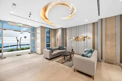a living room with two couches and a chandelier at Yacht Bay Tower 1min to Metro, Tram and 5min to Marina in Dubai