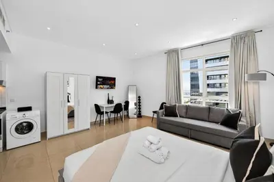 a living room with a couch and a table at Yacht Bay Tower 1min to Metro, Tram and 5min to Marina in Dubai